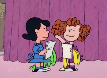 Movie still from “A Charlie Brown Christmas” (1965), directed by Bill Melendez – Two cartoon characters one of which is holding a banana and one of which is holding a newspaper; Medium shot, Over the shoulder angle