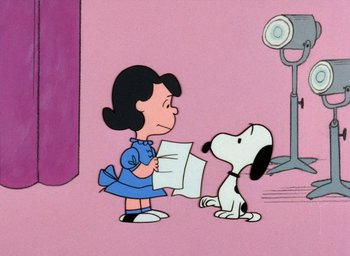 Movie still from “A Charlie Brown Christmas” (1965), directed by Bill Melendez – A cartoon of a woman holding a paper and a dog; Extreme Wide shot, High angle