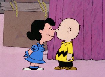 Movie still from “A Charlie Brown Christmas” (1965), directed by Bill Melendez – A charlie brown and lucy cartoon character kissing each other; Medium shot, Over the shoulder angle