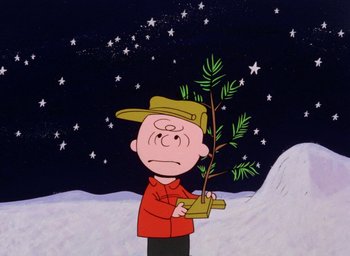 Movie still from “A Charlie Brown Christmas” (1965), directed by Bill Melendez – A charlie brown cartoon character holding a plant; Medium shot, Low angle
