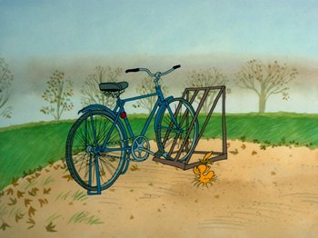 Movie still from “A Charlie Brown Thanksgiving” (1973), directed by Phil Roman – A blue bicycle parked next to a bike rack on a dirt road; Wide shot, High angle