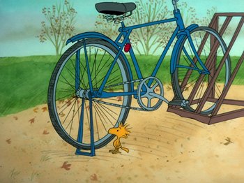 Movie still from “A Charlie Brown Thanksgiving” (1973), directed by Phil Roman – A bicycle chained to the ground next to a bike rack; Wide shot, High angle