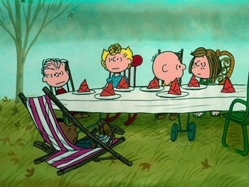 Movie still from “A Charlie Brown Thanksgiving” (1973), directed by Phil Roman – A group of people sitting at a table with a picnic blanket; Extreme Wide shot, High angle