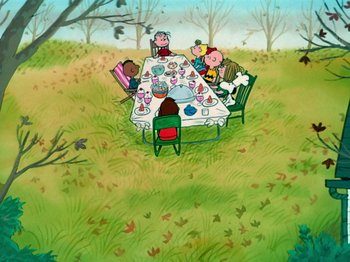 Movie still from “A Charlie Brown Thanksgiving” (1973), directed by Phil Roman – A group of people sitting around a table in the grass; Extreme Wide shot, High angle