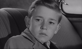 Movie still from “A Child Is Waiting” (1963), directed by John Cassavetes – A young boy sitting in a car looking at the camera; Close Up shot, High angle