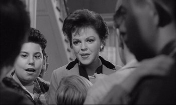 Movie still from “A Child Is Waiting” (1963), directed by John Cassavetes – An old black and white photo of a woman in a suit; Close Up shot, Over the shoulder angle