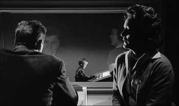 Movie still from “A Child Is Waiting” (1963), directed by John Cassavetes – Two men in suits are reflected in a mirror; Medium shot, Over the shoulder angle