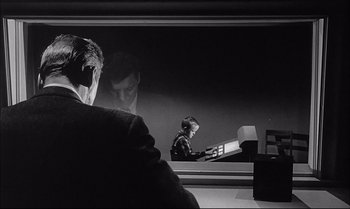 Movie still from “A Child Is Waiting” (1963), directed by John Cassavetes – A man sitting at a desk in front of a mirror; Medium shot, Over the shoulder angle