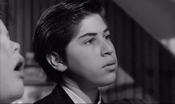 Movie still from “A Child Is Waiting” (1963), directed by John Cassavetes – A young man in a suit looking to his left; Close Up shot, Low angle