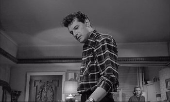 Movie still from “A Child Is Waiting” (1963), directed by John Cassavetes – A black and white photo of a man standing in a room; Medium shot, Low angle