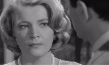 Movie still from “A Child Is Waiting” (1963), directed by John Cassavetes – A black and white photo of a woman with a pearl necklace; Close Up shot, Over the shoulder angle