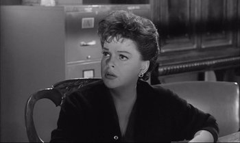 Movie still from “A Child Is Waiting” (1963), directed by John Cassavetes – A black - and - white photo of a woman sitting in a chair; Close Up shot, Over the shoulder angle