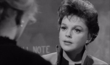 Movie still from “A Child Is Waiting” (1963), directed by John Cassavetes – An old black and white photo of a woman looking at the camera; Close Up shot, Over the shoulder angle