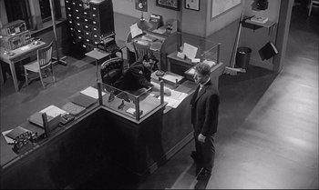 Movie still from “A Child Is Waiting” (1963), directed by John Cassavetes – A man standing in front of a desk in an office; Wide shot, High angle