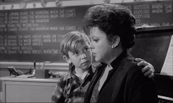 Movie still from “A Child Is Waiting” (1963), directed by John Cassavetes – A woman and a young boy standing next to each other; Medium shot, Over the shoulder angle