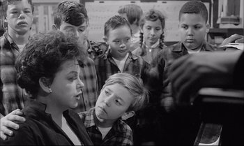 Movie still from “A Child Is Waiting” (1963), directed by John Cassavetes – A group of children standing next to each other in a classroom; Medium shot, Over the shoulder angle
