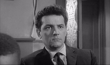 Movie still from “A Child Is Waiting” (1963), directed by John Cassavetes – Black and white photograph of a man wearing a suit and tie; Close Up shot, Low angle