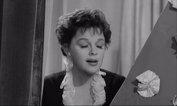 Movie still from “A Child Is Waiting” (1963), directed by John Cassavetes – An old photo of a woman looking in a mirror; Close Up shot, Over the shoulder angle