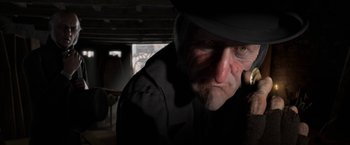 Movie still from “A Christmas Carol” (2009), directed by Robert Zemeckis – An old man wearing a black hat and a black suit; Close Up shot, Over the shoulder angle