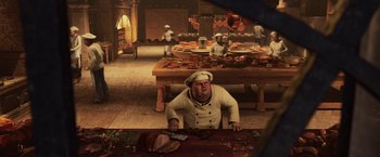 Movie still from “A Christmas Carol” (2009), directed by Robert Zemeckis – An image of a chef in a kitchen preparing food; Wide shot, High angle