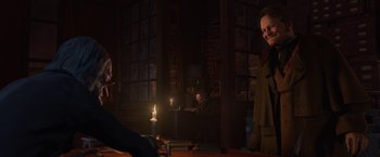 Movie still from “A Christmas Carol” (2009), directed by Robert Zemeckis – Two people sitting in a dark room with a lit candle; Medium shot, Over the shoulder angle