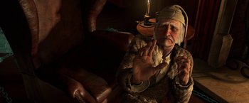 Movie still from “A Christmas Carol” (2009), directed by Robert Zemeckis – An old man sitting on a couch in a dark room; Close Up shot, High angle