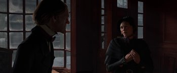 Movie still from “A Christmas Carol” (2009), directed by Robert Zemeckis – Two people are talking in front of a window; Medium shot, Over the shoulder angle