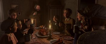 Movie still from “A Christmas Carol” (2009), directed by Robert Zemeckis – A group of people sitting around a table with food; Medium shot, High angle