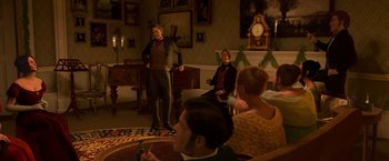 Movie still from “A Christmas Carol” (2009), directed by Robert Zemeckis – A group of people sitting in a living room; Wide shot, Over the shoulder angle