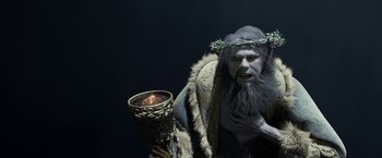 Movie still from “A Christmas Carol” (2009), directed by Robert Zemeckis – An image of a man with a beard holding a candle; Medium shot, Over the shoulder angle