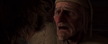 Movie still from “A Christmas Carol” (2009), directed by Robert Zemeckis – An old man with a beard and a hat is looking angry; Close Up shot, Over the shoulder angle
