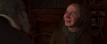 Movie still from “A Christmas Carol” (2009), directed by Robert Zemeckis – An older woman sitting in a chair in front of a fireplace; Close Up shot, High angle