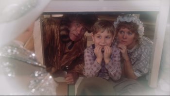 Movie still from “A Christmas Story” (1983), directed by Bob Clark – A man and two women and a boy sitting on the floor; Medium shot, Low angle