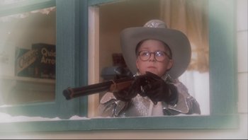 Movie still from “A Christmas Story” (1983), directed by Bob Clark – A young boy wearing a cowboy hat and holding a gun; Close Up shot, Low angle