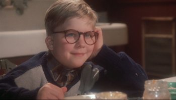Movie still from “A Christmas Story” (1983), directed by Bob Clark – A young boy wearing glasses sitting in front of a bowl of food; Close Up shot, Low angle