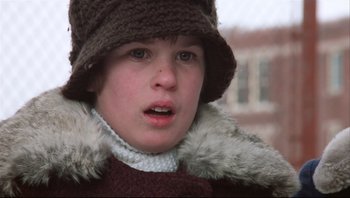 Movie still from “A Christmas Story” (1983), directed by Bob Clark – A young boy wearing a hat and a fur coat; Close Up shot, Low angle