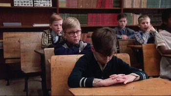 Movie still from “A Christmas Story” (1983), directed by Bob Clark – A group of young boys sitting at a desk; Medium shot, High angle