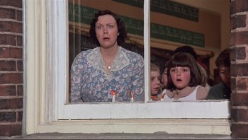 Movie still from “A Christmas Story” (1983), directed by Bob Clark – A woman and two children looking out of a window; Medium shot, Low angle