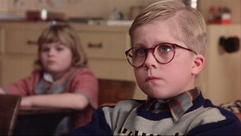 Movie still from “A Christmas Story” (1983), directed by Bob Clark – A young boy wearing glasses and sitting next to a young girl; Close Up shot, Low angle