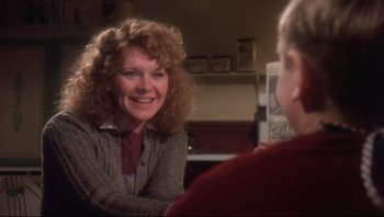 Movie still from “A Christmas Story” (1983), directed by Bob Clark – A woman sitting in front of another woman in a room; Close Up shot, Over the shoulder angle