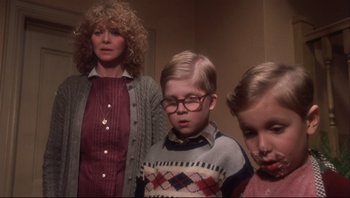 Movie still from “A Christmas Story” (1983), directed by Bob Clark – A woman standing next to two young children; Medium shot, Low angle