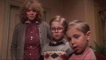 Movie still from “A Christmas Story” (1983), directed by Bob Clark – A woman standing next to two young children; Medium shot, Low angle
