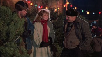 Movie still from “A Christmas Story” (1983), directed by Bob Clark – A woman wearing a red scarf standing next to two other people; Medium shot, Over the shoulder angle