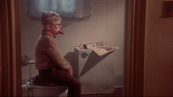 Movie still from “A Christmas Story” (1983), directed by Bob Clark – A boy sitting on top of a toilet in a bathroom; Medium shot, Low angle