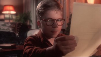 Movie still from “A Christmas Story” (1983), directed by Bob Clark – A young boy wearing glasses looking at a piece of paper; Close Up shot, High angle