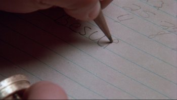 Movie still from “A Christmas Story” (1983), directed by Bob Clark – A person writing on a piece of lined paper; Extreme Close Up shot, High angle