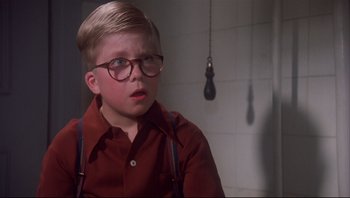 Movie still from “A Christmas Story” (1983), directed by Bob Clark – A young boy wearing glasses and a red shirt; Close Up shot, Low angle