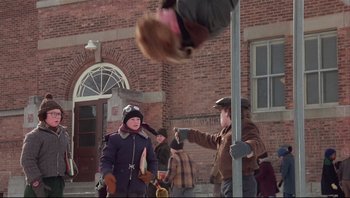 Movie still from “A Christmas Story” (1983), directed by Bob Clark – A man is flying a kite in front of a building; Wide shot, Low angle