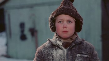 Movie still from “A Christmas Story” (1983), directed by Bob Clark – A young boy wearing a hat and a jacket; Close Up shot, Low angle