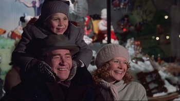 Movie still from “A Christmas Story” (1983), directed by Bob Clark – A man and a woman and a child are smiling for the camera; Medium shot, Low angle